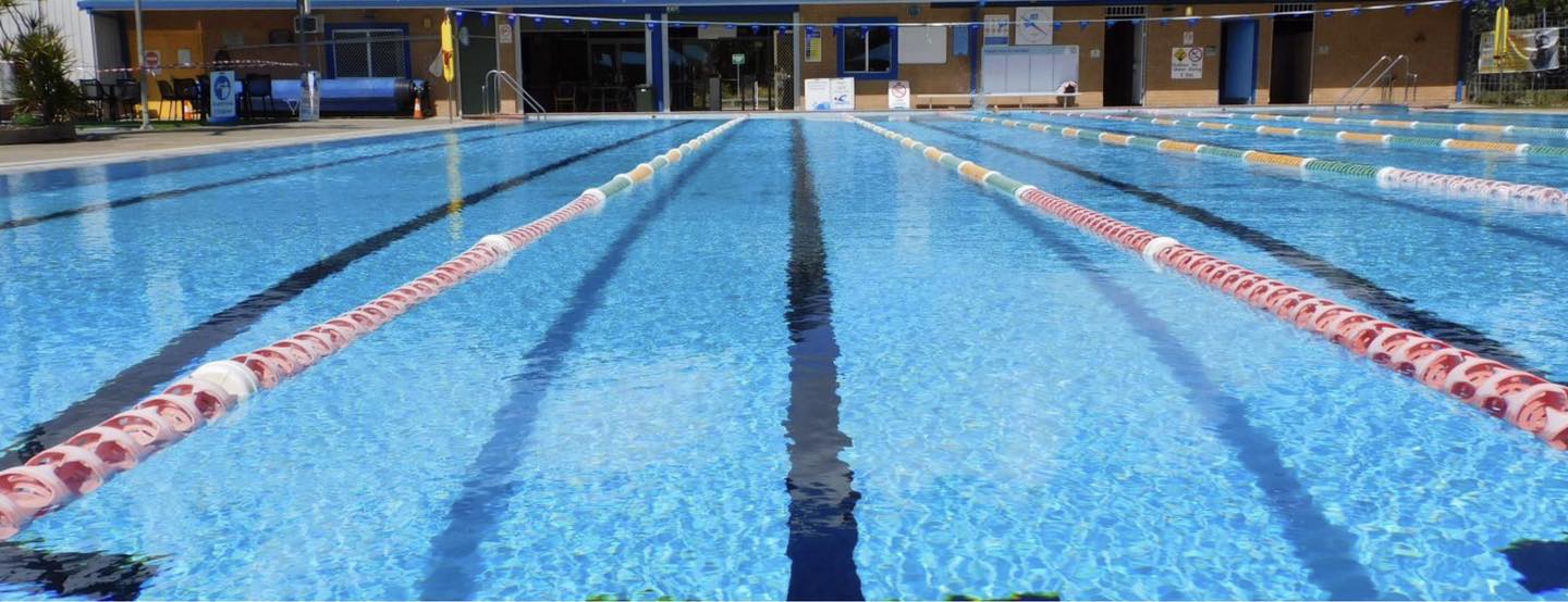 Tilligerry Aquatic Centre Pool featured in this photo. The water appears still and blue. Close up shot of a lane.